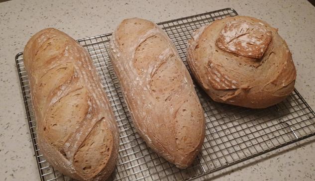 Three loaves of bread are cooling
 Two oblong ones and a boule.