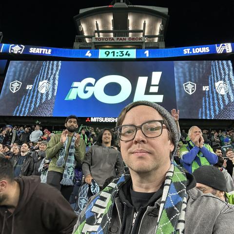 A selfie of the author, in front of a scoreboard reading “Seattle 4, St. Louis 1”.
