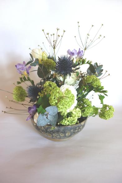 Blumengesteckt mit blauen,  weißen und hellgrünen Blüten.