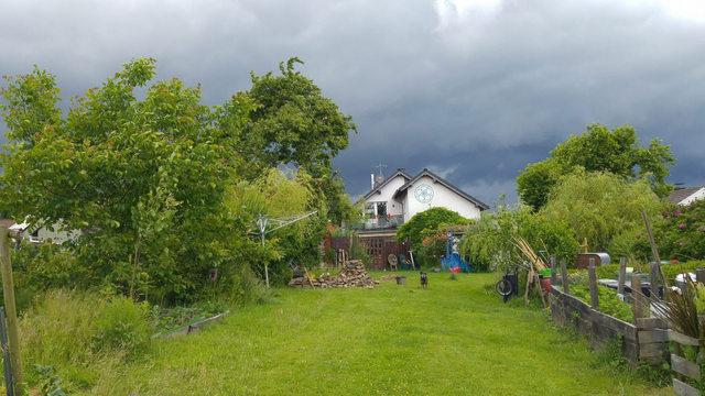 Großer Garten vor Gewitterwolken