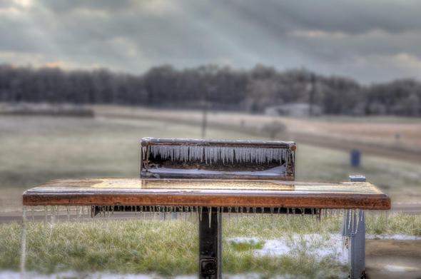 Icicles hang from a park grill, indicating a recent ice storm.