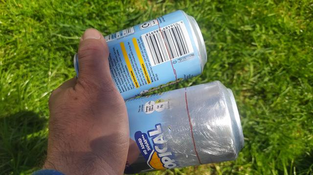 Two drinks cans with the ends marked with a cut line around 35mm from the ends. 