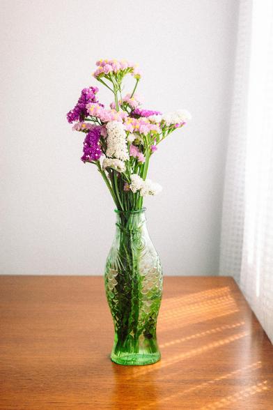 4 - Kodak Ultramax wannabe preset. Photograph of a fish-shaped pot filled with colorful flowers on a wooden table, with sunlight filtering through the curtains. The scene is well lit and has lots of contrast and saturation.