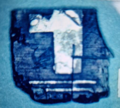 Piece of broken electricity board, with a shape looking like a 1. It has quite clean edges and a clear horizontal marking