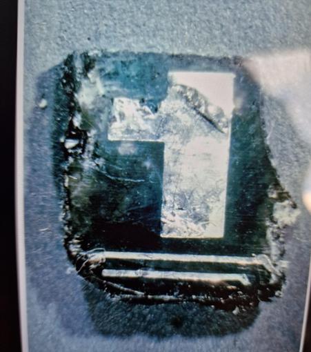 Piece of broken electricity board  with a shape looking like a 1. It has rough edges without the clear horizontal marking