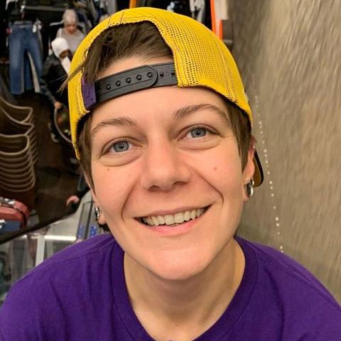 Image shows Steph, who is wearing a yellow cap backwards and a purple T-shirt.