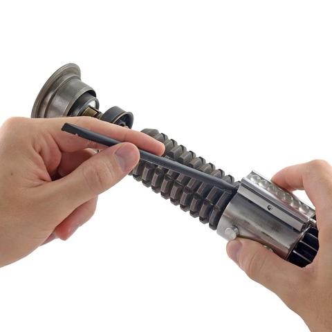 POV image on a white background of someone holding a lightsaber with their right hand and using a spudger with their left to lift up a piece of its handle.