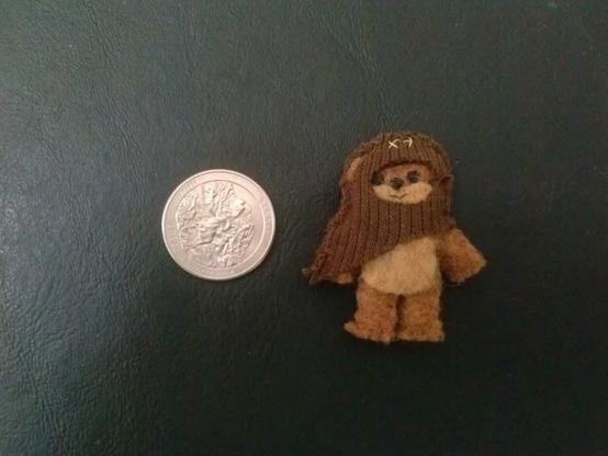 Tiny handmade ewok next to a dime for size comparison.
