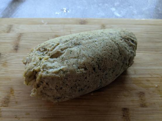 Eine unförmige Rolle Semmelknödel auf einem Bambus Schneidbrett 