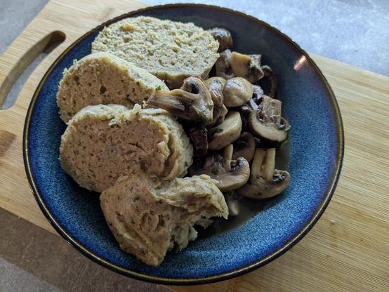 Ein Teller: Champignons mit Petersilie im eigenen Saft gebraten, mit vier Scheiben Serviettenknödel darüber