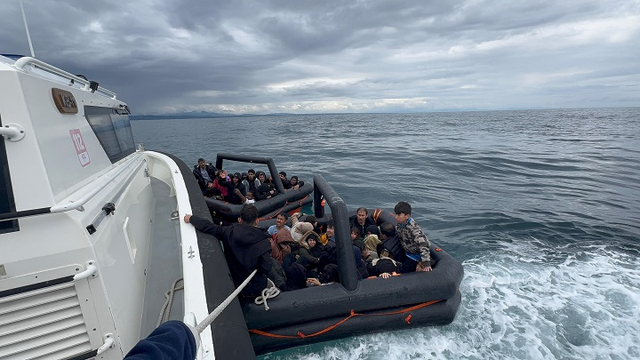 Menschen ohne Rettungswesten dicht gedrängt in zwei Rettungsflößen bei einem türkischen Küstenwachboot.