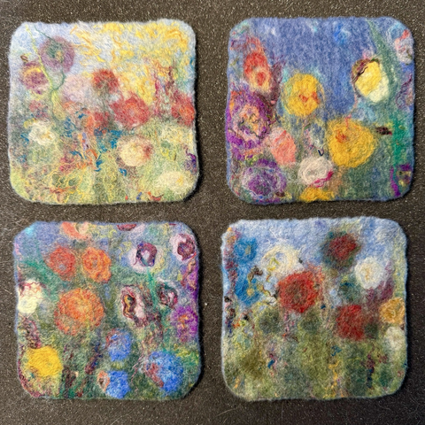 Four wet felted coasters with multi coloured floral designs. Squares with rounded corners.