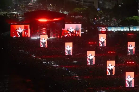 a huge crowd with images of lady gaga on screens