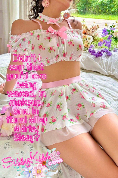 A woman in a vibrant floral dress sits gracefully on a bed, surrounded by soft pillows, colorful flowers, and lovely sunlight. "Didn't I say that you'd love being waxed, in makeup. and in floral satin skirts, Sissy?"