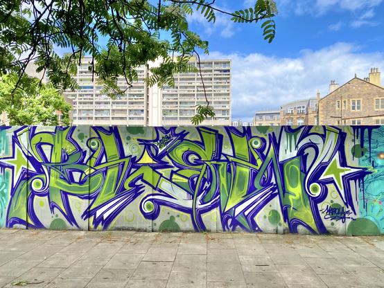Vibrant green, blue, and white graffiti piece that maybe says Blew