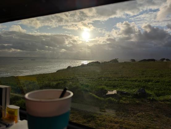 Zwischen dicken Regenwolken lugt die Sonne hervor und scheint auf die Bucht der Seine.