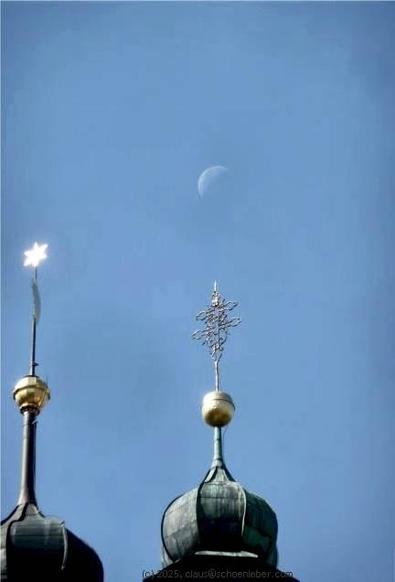 Ein Schnappschuss auf einer Fahrt durch Tschechien

Auf dem Dach eines tschechischen Klosters sind nur die Spitzen zweier "Zwiebeltürme" zu sehen. Es ist ein sonniger Tag, der Himmel ist wolkenlos und blau.

Auf der Spitze des linken Turms ist ein in der Sonne glänzender sechszackiger, ausgefüllter Stern zu sehen. Auf dem zweiten Turm, der in der vertikalen Mitte des Bildes zu sehen ist, ist ein filigran gearbeitetes Doppelkreuz ("Patriarchenkreuz") zu sehen, das ebenfalls in der Sonne glänzt. In der Perspektive über diesem ist der abnehmende Halbmond zu sehen, der an diesem Mittag hoch am Himmel stand.

