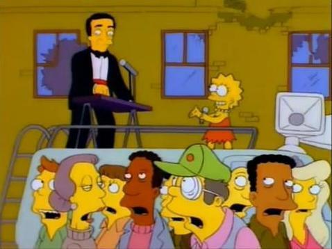 Paul Anka tocando el órgano con Lisa Simpson sobre una furgoneta con megáfonos, intentando captar la atención del público.