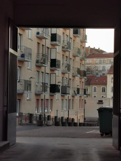 Vue par une porte cochère vers la cour d'un immeuble