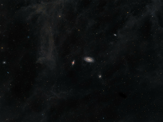 shot of the night sky with lot of stars and some interstellar dust. Two prominent galaxies in the middle with containing little red regions representing ionized hydrogen