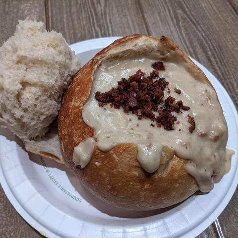 Cheddar ale soup in a sourdough bread bowl with crumbled bacon on top.