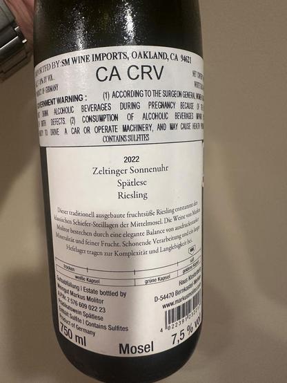 Rear of the bottle of wine.

Scanned:

“WORTED BY SM WINE IMPORTS, OAKLAND, CA 94621 CA CRV
2 BY VOI.
DIT UP CERMANY
ETERNMENT WARNING:
ALCONOLIC BEVERAGES DURING PREGNANCY BECAUSE OF DEFECTS. (2) CONSUMPTION OF ALCOHOLIC BEVERAGES RE IN TO DANE A CAR OR OPERATE MACHINERY, AND MAY CAUSE HENT NO CONTAINS SULFTIES
2022
Zeltinger Sonnenuhr
Spätlese
Riesling
Dieser traditionell ausgebaute fruchtsüße Riesling entstammrden klassischen Schiefer-Steillagen der Mittelmosel. Die Weine von Makes Molicor bestechen durch eine elegante Balance von ausdrucksrade Mineralicät und feiner Frucht. Schonende Verarbeitung und ein lig Hefelager tragen zur Komplexität und Langlebigkeit hi.
trocken
goktene keny
weiße Kapsel
(sasailing ) Estate bottled by
ein gut Markus Molitor
grüne Kapsel
Haus Klastetes
APr. 2 576 609 022 23
D-54470 Bernkaste: es
Prädikatswein Spätlese
wwww.markusmalacan
Kanält Sulfite | Contains Sulfites
roduct of Germany
160 %
4 022391123227
Mosel”