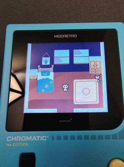 An image a blue Modretro Chromatic displaying the player character standing in their room from the start of Winsley's Guardian.