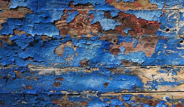 Wooden boards with peeling blue paint.