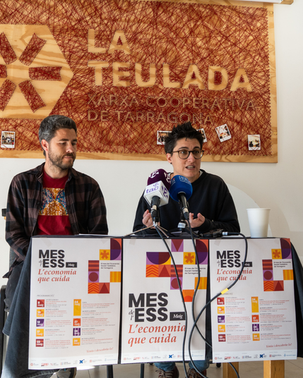 Membres de La Teulada i CoopCamp amb la cartelleria de la programació