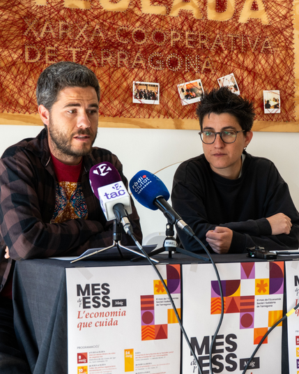 Membres de La Teulada i CoopCamp amb la cartelleria de la programació