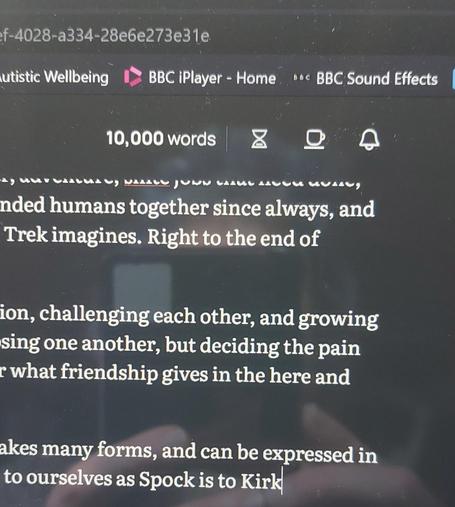A photo of a writing document on my laptop, white writing on a black background. It shows I just hit 10,000 words, with the word "Kirk" having the cursor after it, as that was my 10,000th word!