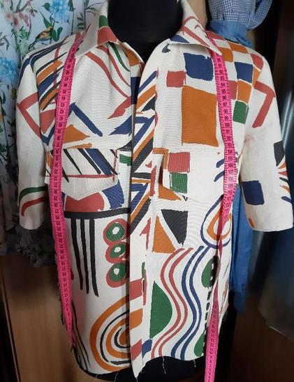 Blouse with short sleeves, shirt collar and pocket flaps on the front.