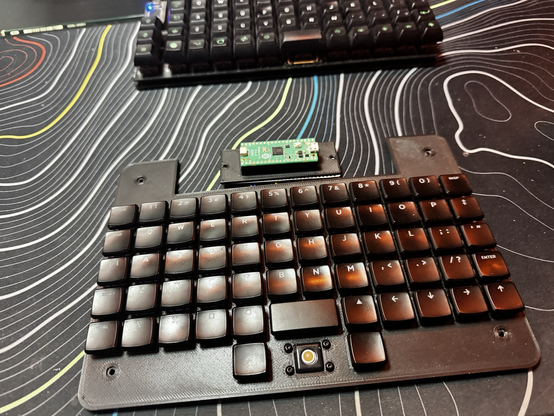 Ortholinear mechanical keyboard 12x5 with a 2u space bar and trackball.
