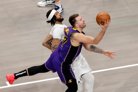 Los Angeles Lakers guard Luka Doncic (77) drives the paint against Dallas Mavericks forward Anthony Davis (3) during the first half of an NBA game, Wednesday, April 9, 2025, in Dallas.(Elías Valverde II / Staff Photographer)