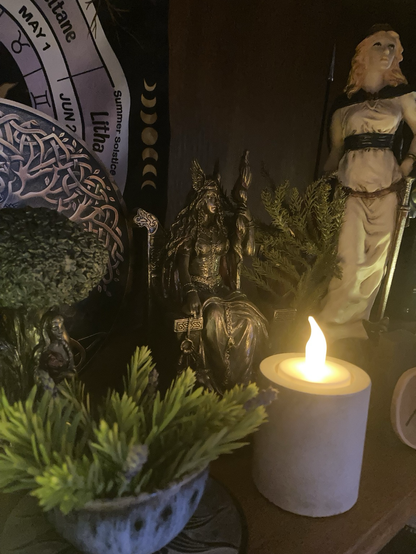 Pagan altar with Frigg and Freya statuettes and offering of yew and lavender