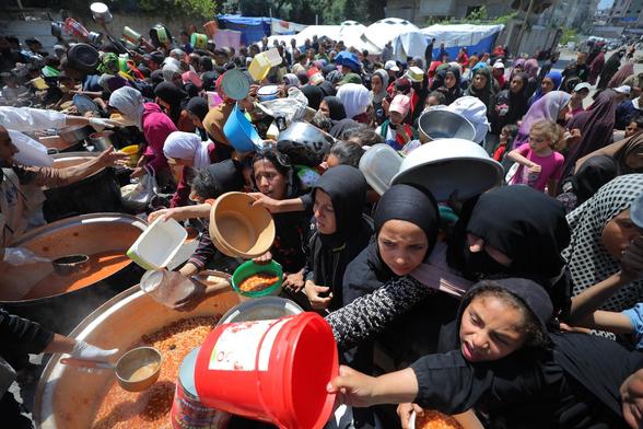 Les Palestiniens déplacés s'alignent pour recevoir un repas dans le nord de la bande de Gaza, le 5 mai 2025.