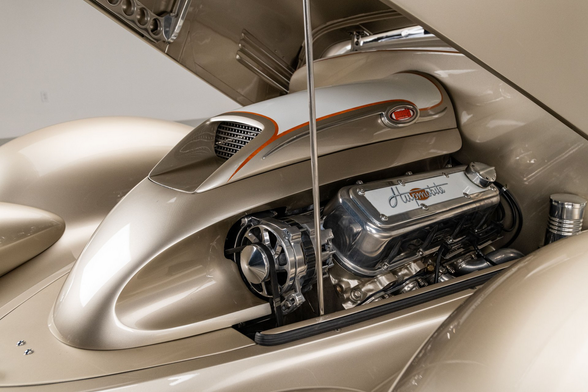 the hood is up, showing he chrome engine 