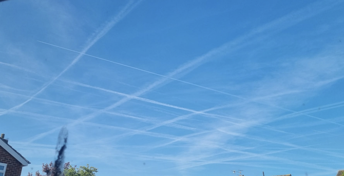 Contrails cross a blue sky in very perpendicular grid pattern, Liverpool 2025