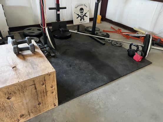 Wooden box, dumbbells, and kettle bells on rubber flooring