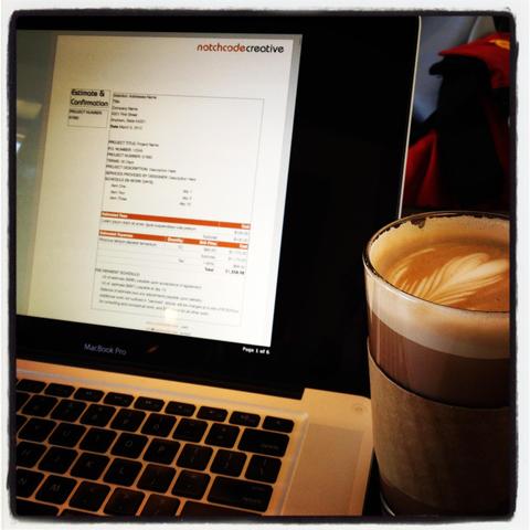 An estimate that I’m writing appears on a laptop screen. A tall frothy coffee drink in a pint glass sits off to one side. 
