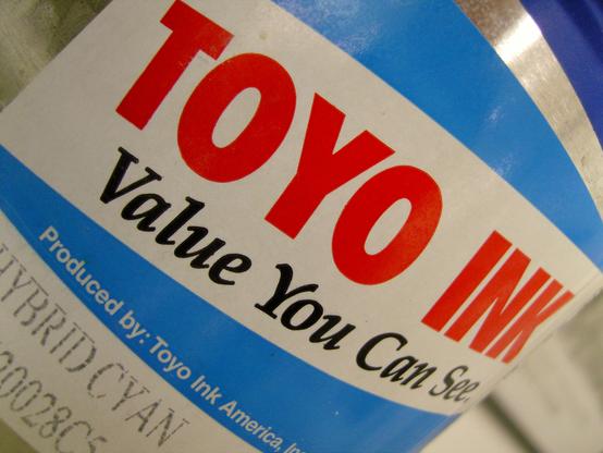 Close up of label on a printing ink can. Blue streaks on a white background above and below big red capital letters reading
TOYO INK
And below it in black:
Value You Can See