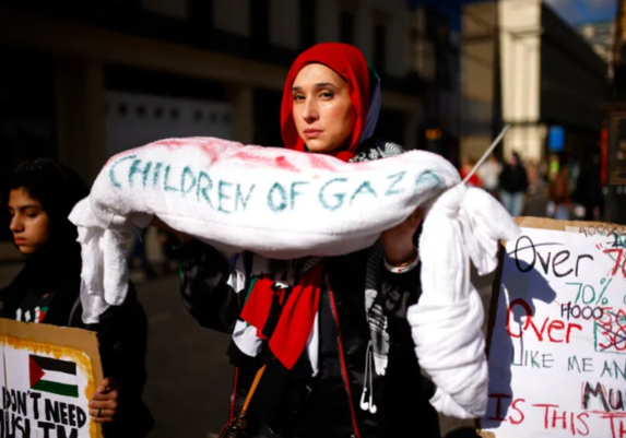 Demonstrator holding shroud labelled children of gaza
