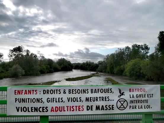Banderole déployée sur un pont du Gave de Pau : ENFANTS : Droits & besoins bafoués, punitions, gifles, viols, meurtres... Violences adultistes de masse. Bayrou, la gifle est interdite par la loi.
