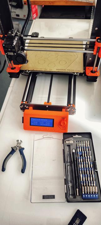 Prusa MK3 i3 under maintenance. A set of screw drivers and pliers.