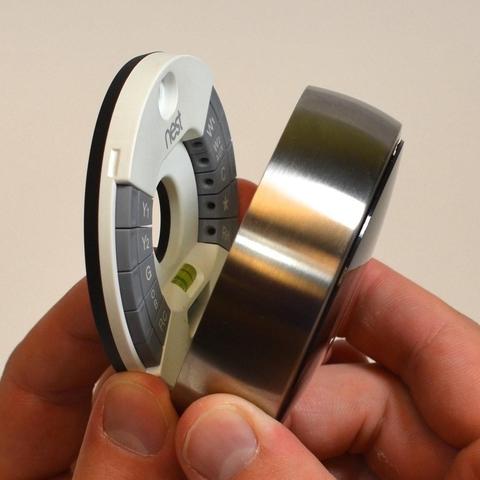 Google Nest thermostat split in half in someone's hands, with the wall plate on the left side and the thermostat itself on the right.