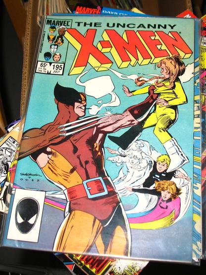 Cover to X-Men 195 with Wolverine holding up Energizer of Power Pack, his claws drawn, almost as if he's going to stab her.