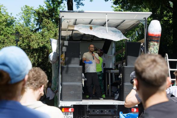 Redner auf dem Lautsprecherwagen vor Teilnehmende.