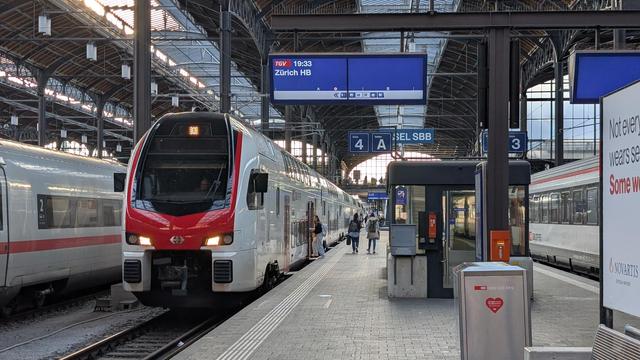 Front view of a SBB RABe 512 at platform 4 in Basel SBB, display at platform showing "TGV, 19:33, Zürich HB"