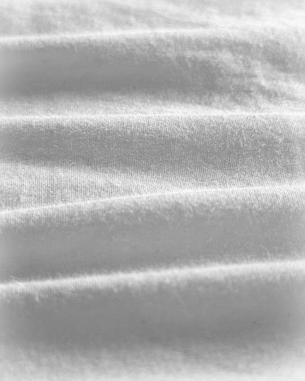 A close up photograph of ripples in a white bedsheet.