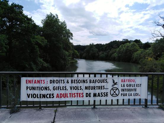 Banderole déployée sur un pont du Gave de Pau : ENFANTS : Droits & besoins bafoués, punitions, gifles, viols, meurtres... Violences adultistes de masse. Bayrou, la gifle est interdite par la loi.